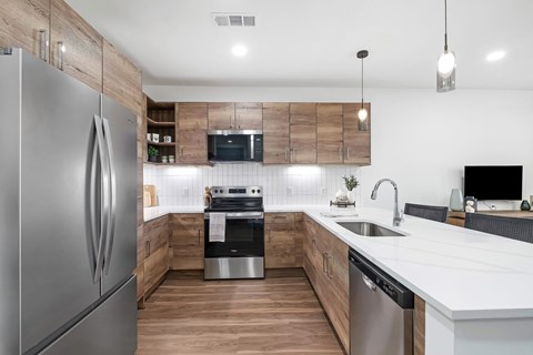 A modern kitchen with a stainless steel refrigerator and wooden accents.