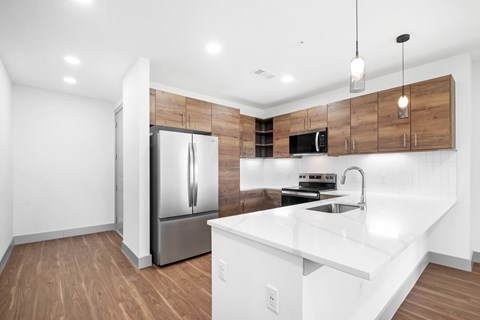 A modern kitchen with a white countertop and a stainless steel refrigerator.