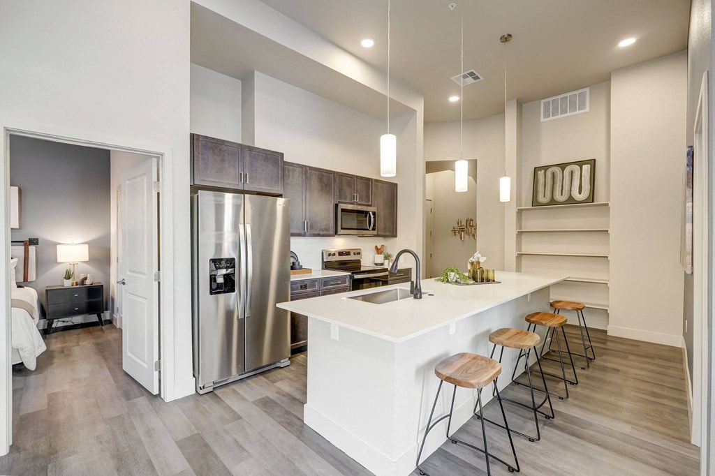 Kitchen with island, pendant lighting and built-in book shelving