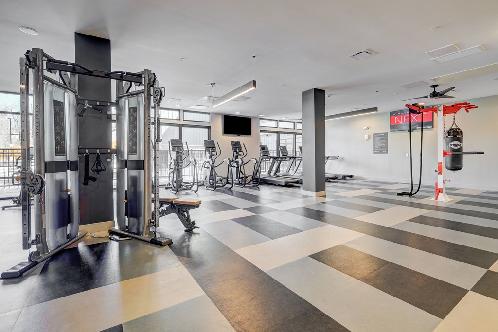 a gym with a checkered floor and weights and cardio equipment