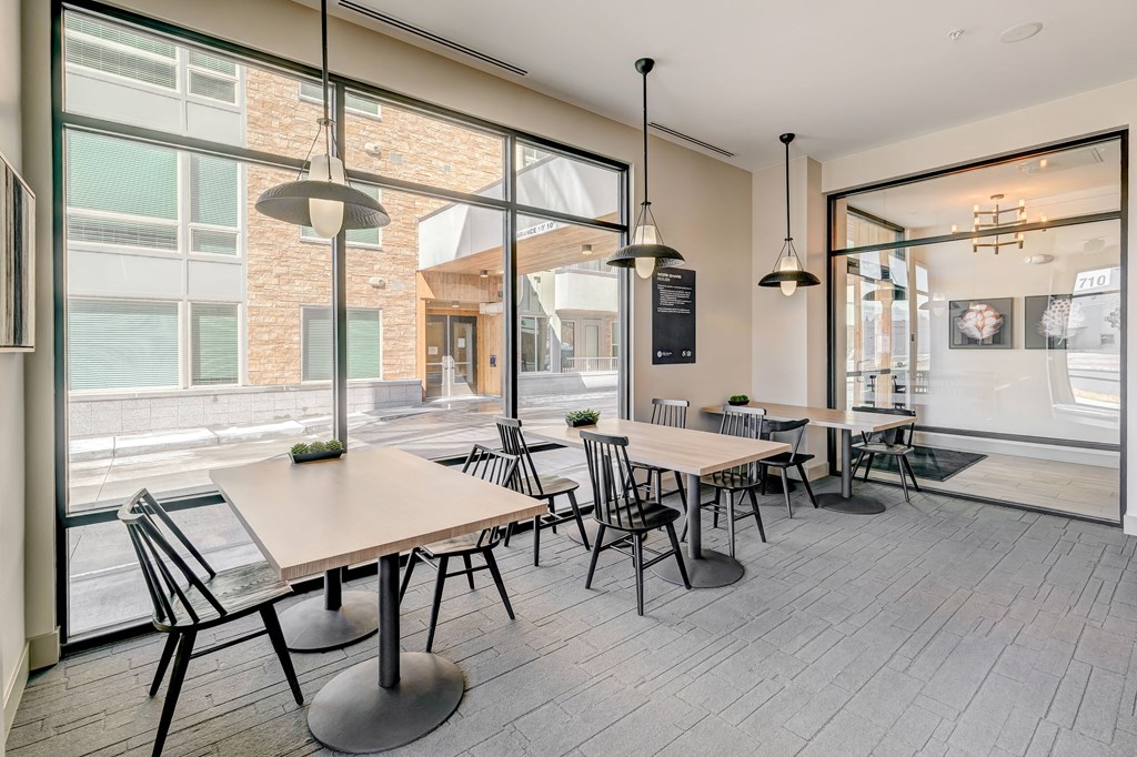 a seating area with tables and chairs in front of a window