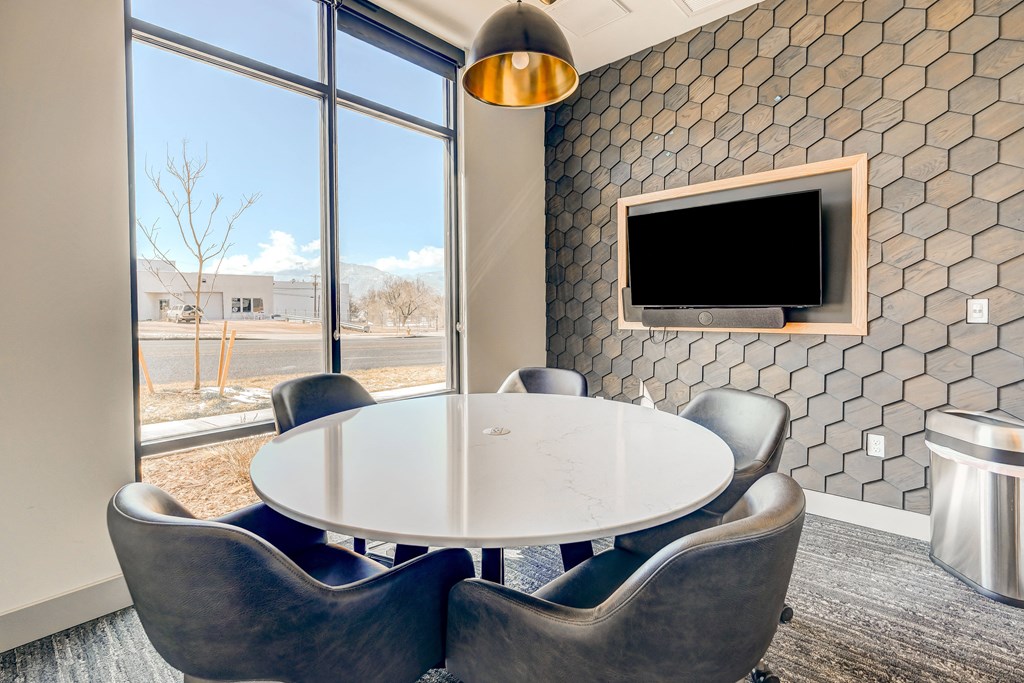 a meeting room with a white table and blue chairs