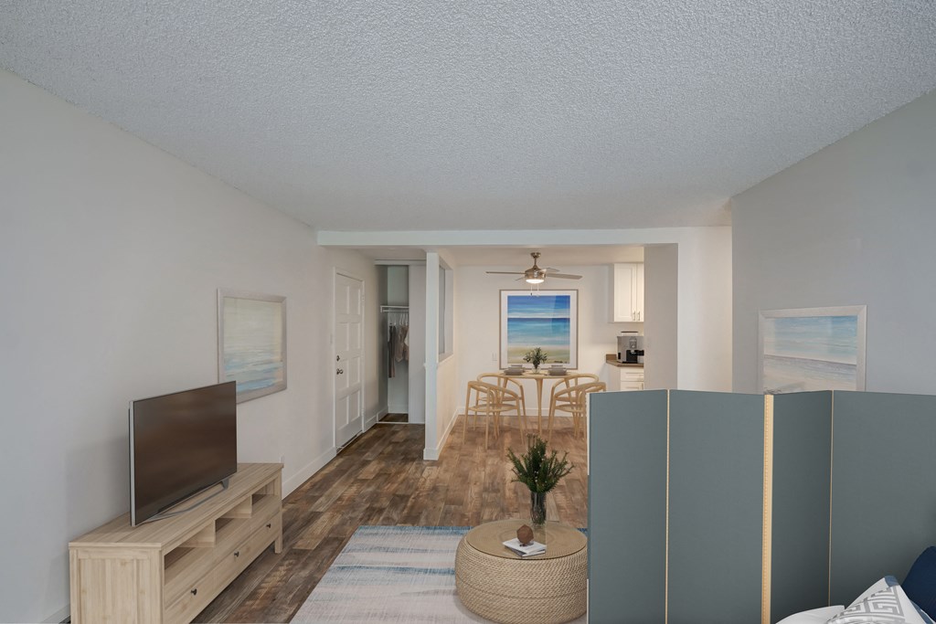 an open living room and dining room with a beach view and a television