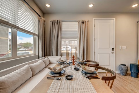 A dining room with a table set for a meal.