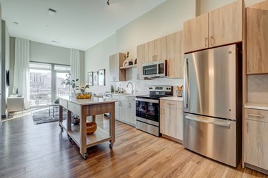 Model kitchen with light wood cabinetry and stainless steel appliances