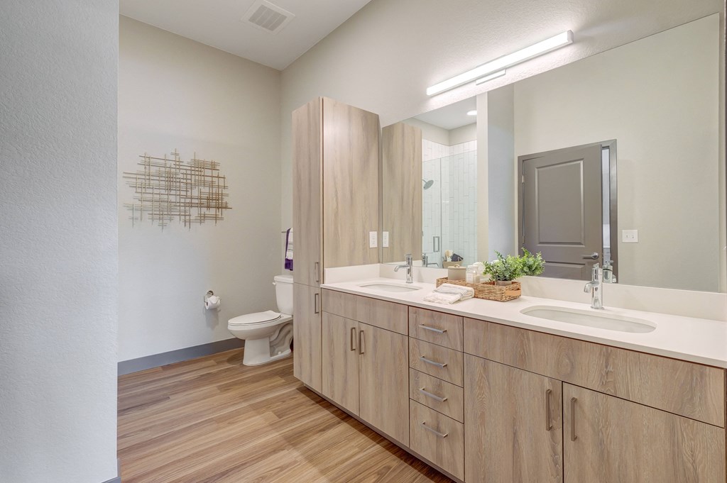 Model bathroom with dual sink vanity and ample storage space at Novus, Colorado, 80124