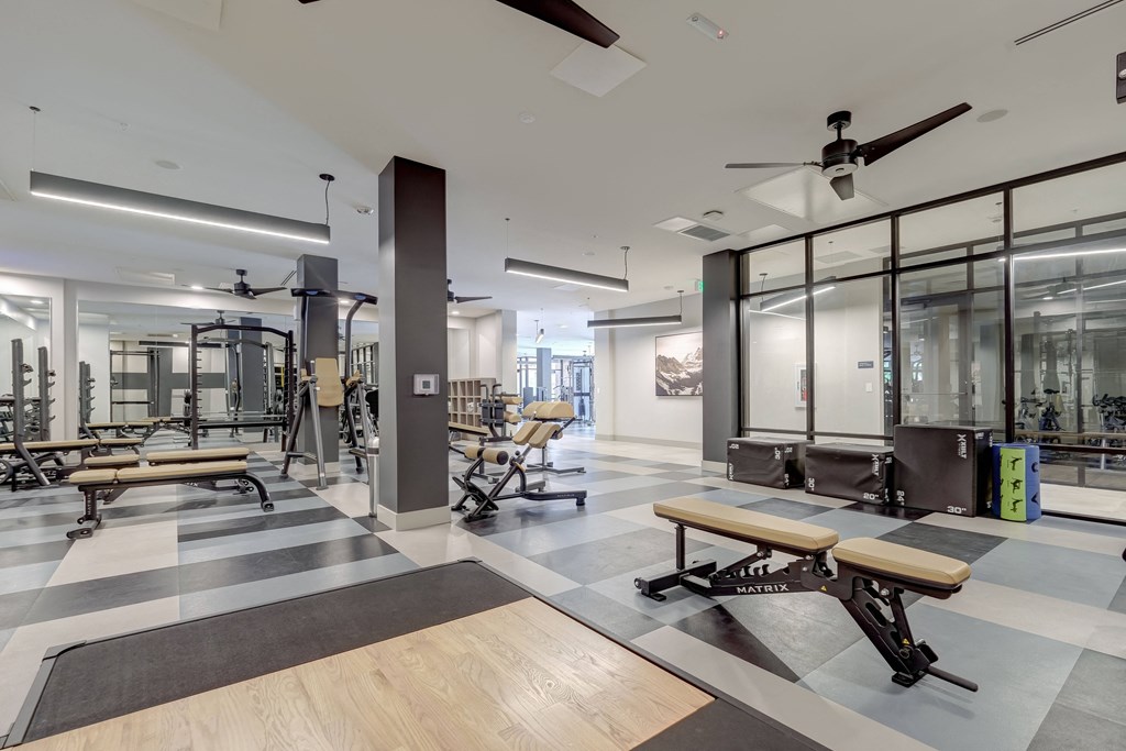 a spacious fitness center with exercise equipment and a black and white checkered floor