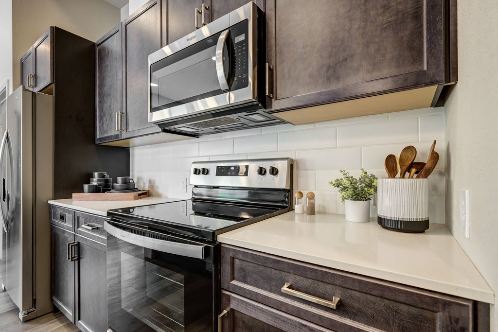 a kitchen with dark cabinets and white countertops