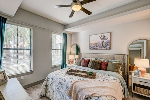 A bedroom with a large bed and a ceiling fan.