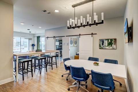 A conference room with a long table and blue chairs.