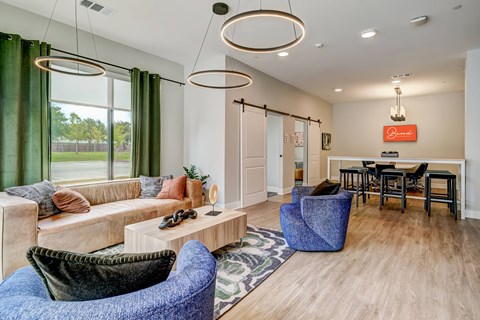 A living room with a blue chair and a sofa.