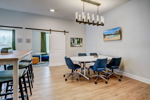 A conference room with a white table and blue chairs.