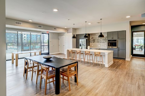 A modern kitchen with a black table and wooden chairs.