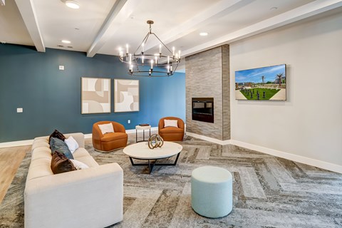 A living room with a white couch, orange chairs, and a grey rug.