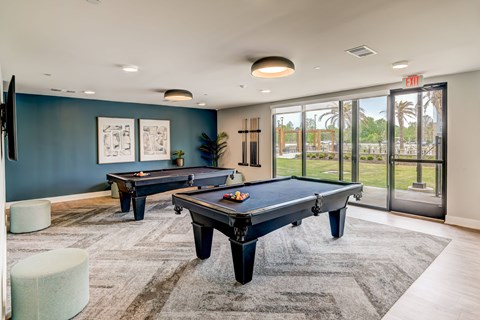 A room with a pool table and a view of the outside.