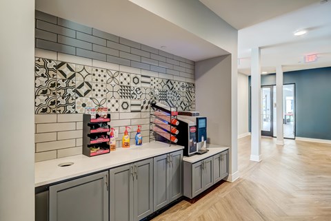 A kitchen area with a tile backsplash and a counter with a few items on it.