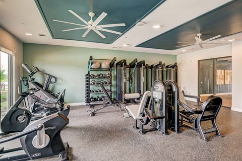 A gym with a variety of equipment including treadmills, weights, and exercise machines.