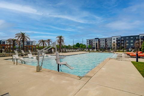 A swimming pool with a slide and lounging chairs.