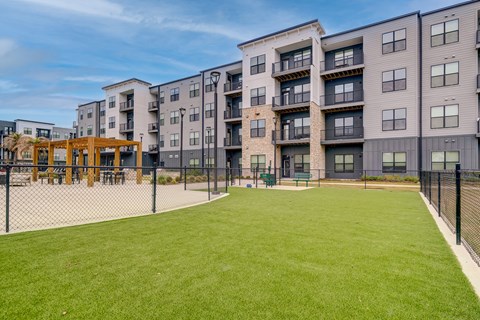 A large grassy area in front of apartment buildings.