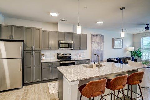 A modern kitchen with a stainless steel refrigerator, a microwave, and a sink.