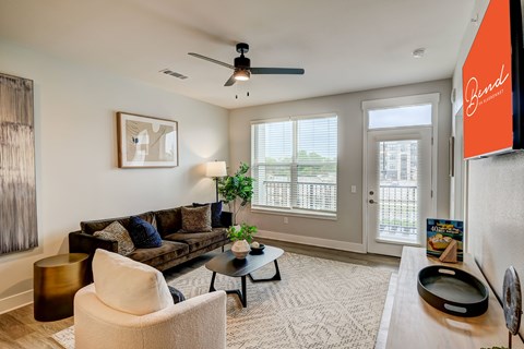 A living room with a sofa, chair, and a painting on the wall.