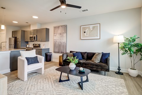 A modern living room with a black coffee table and a grey sofa.