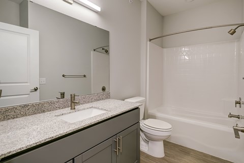 A bathroom with a sink, toilet, and bathtub.