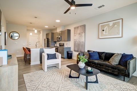 A modern living room with a black couch and a coffee table.