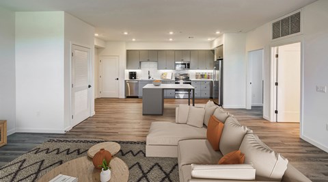 a living room with a couch and a kitchen in the background