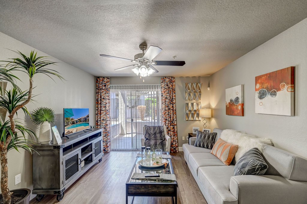 a living room with a white couch and a ceiling fan