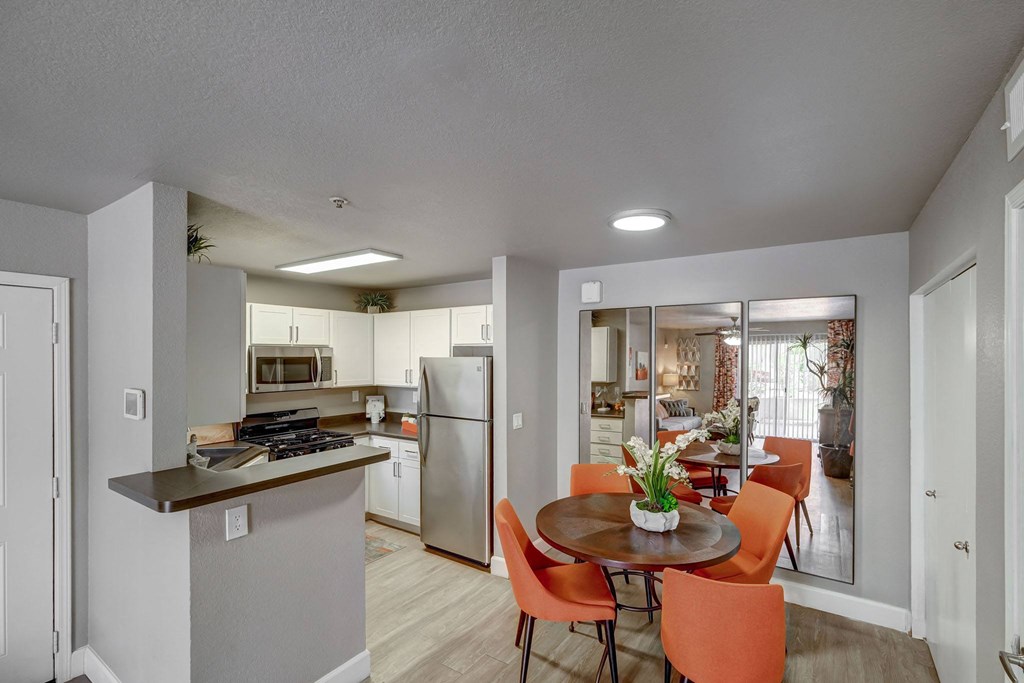 a kitchen and dining room with stainless steel appliances and a table and chairs