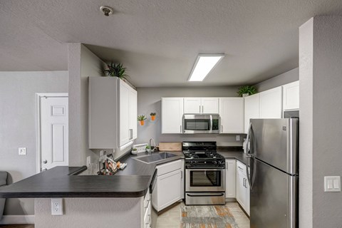 a kitchen with stainless steel appliances and white cabinets