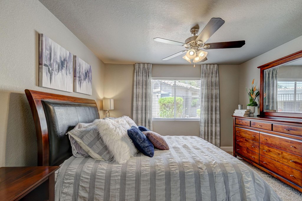 a bedroom with a large bed and a ceiling fan