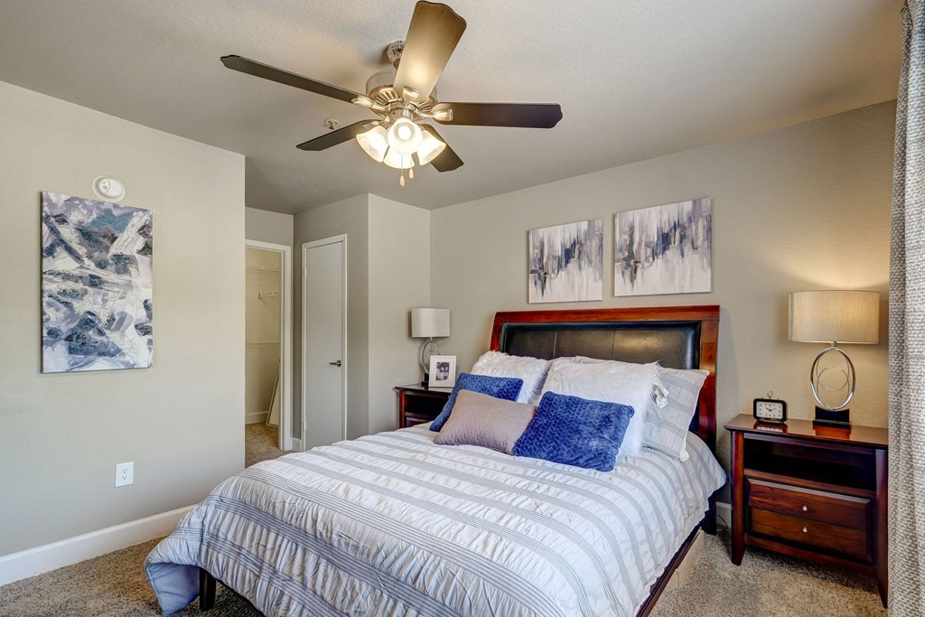 a bedroom with a bed and a ceiling fan