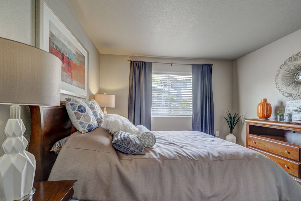 a bedroom with a bed and a dresser and a window
