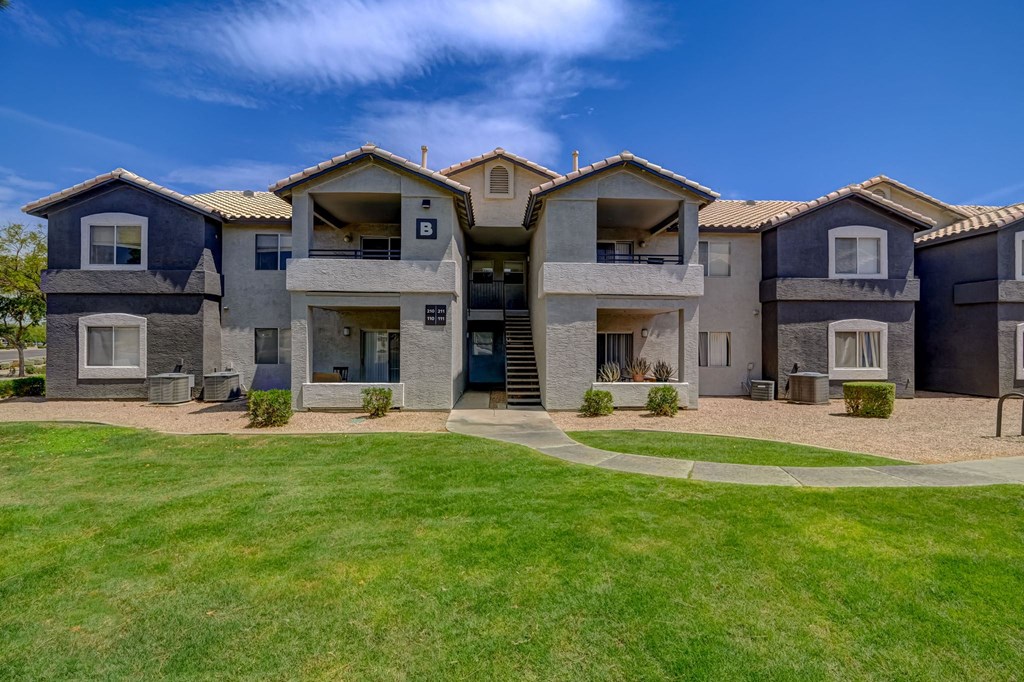two story houses with balconies and a green lawn