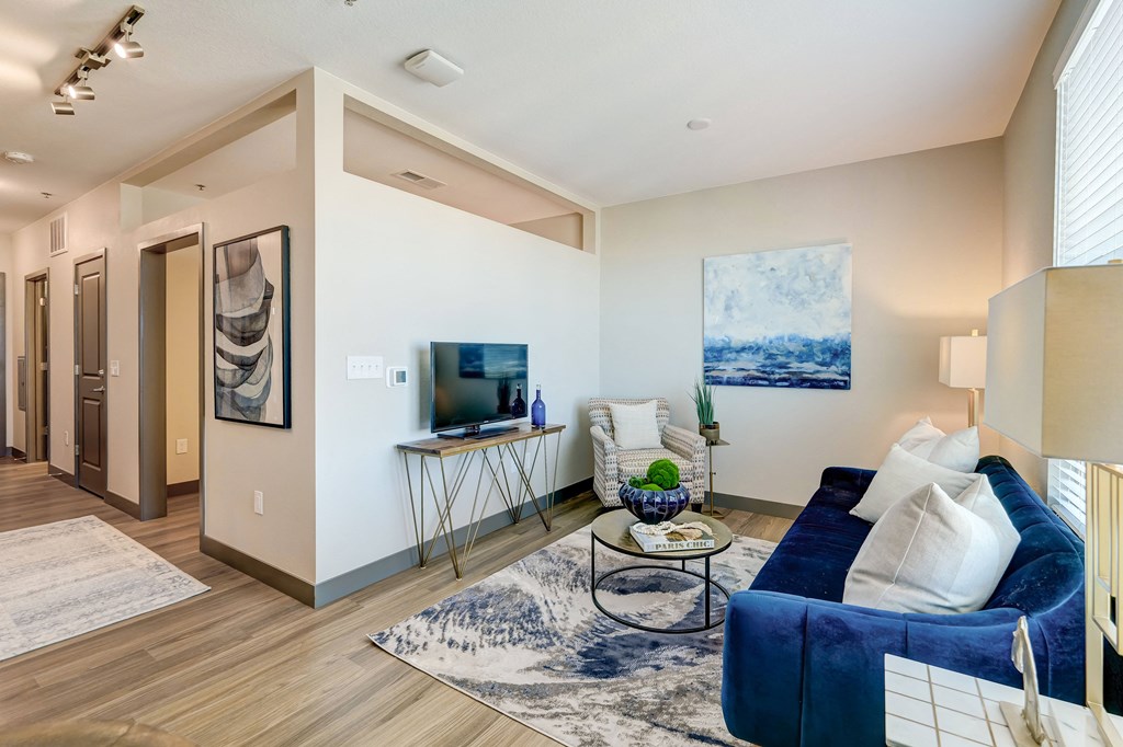 a living room with a blue couch and a tv on a stand  at Novus, Lone Tree, 80124