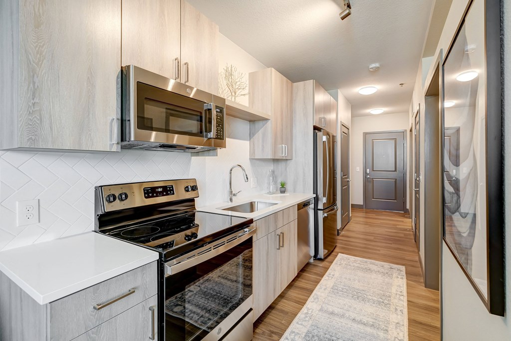 a kitchen with white cabinets and stainless steel appliances at Novus, Lone Tree, CO