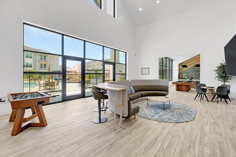 A modern living room with a large window and a view of a building outside.