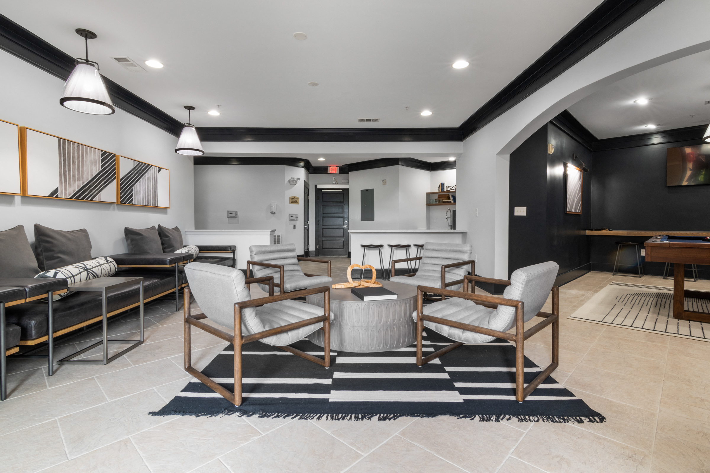 A modern living room with a black and white striped rug and a wooden coffee table.