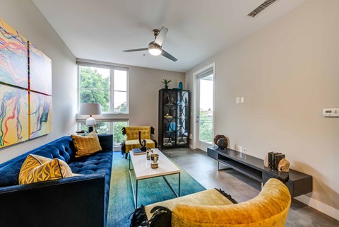 A living room with a blue couch and a yellow chair.