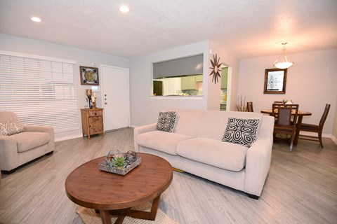 A living room with a white couch and a wooden coffee table.