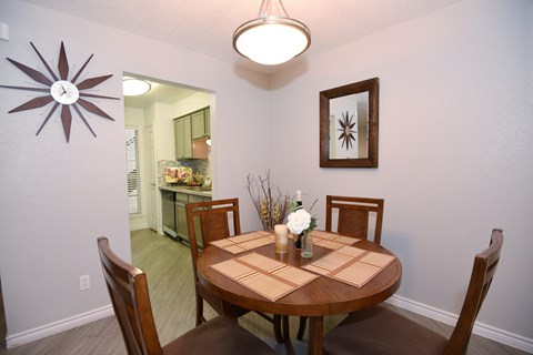 A dining room with a table set for two. Un comedor con una mesa puesta para dos personas.
