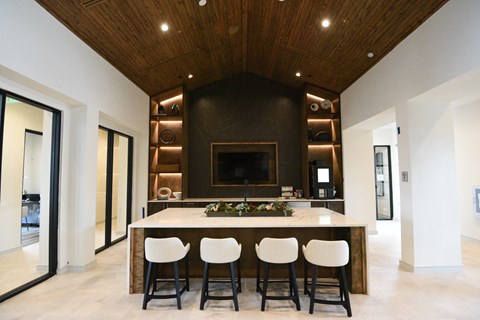 a large kitchen with a center island with four chairs