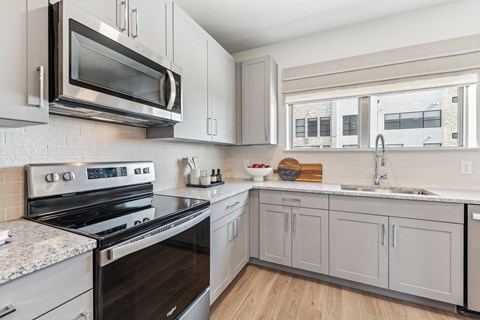 a kitchen with white cabinets and stainless steel appliances