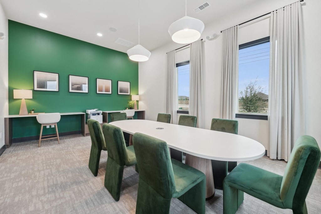 A conference room with green chairs and a white table.