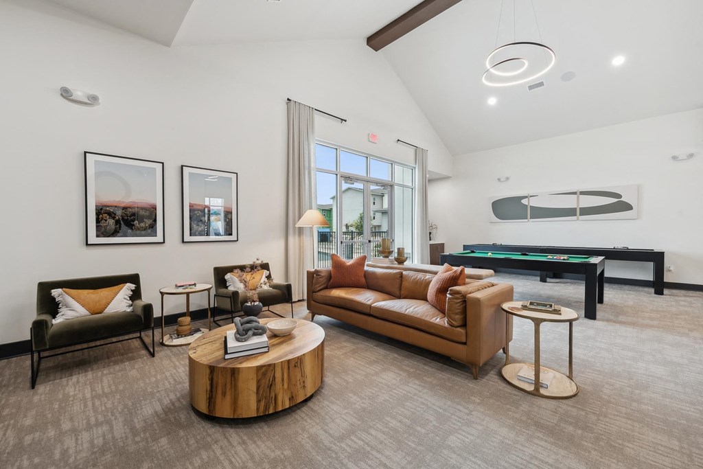 A living room with a pool table and a couch.
