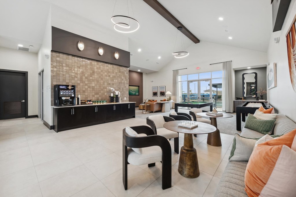 A modern living room with a kitchen area in the background.