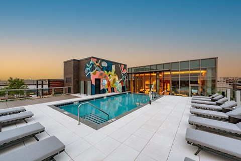 a pool on the rooftop of a building with a mural on the side