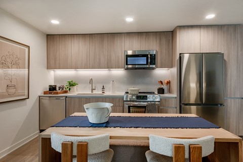 A modern kitchen with a dining table and chairs.